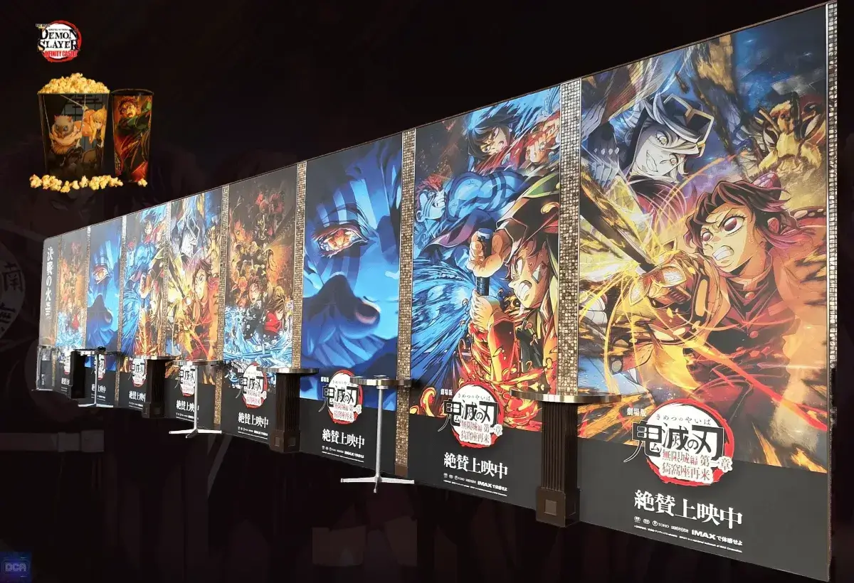 Foto de um banner promocional em um cinema para os filmes da Saga Final de Demon Slayer, ilustrando a análise sobre a divisão do Arco do Castelo Infinito e da Contagem Regressiva para o Amanhecer em uma trilogia.